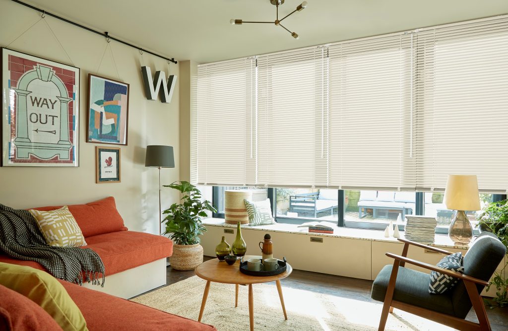 Cream metal Venetian blinds across a living room window
